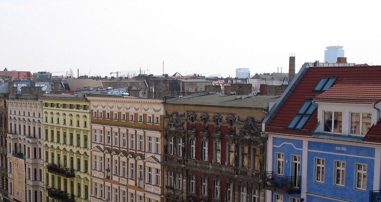 Blick über die Fassadenzeile der Altbauten in der Oderberger Straße in Berlin-Prenzlauer Berg, dahinter die Dachlandschaft des Viertels