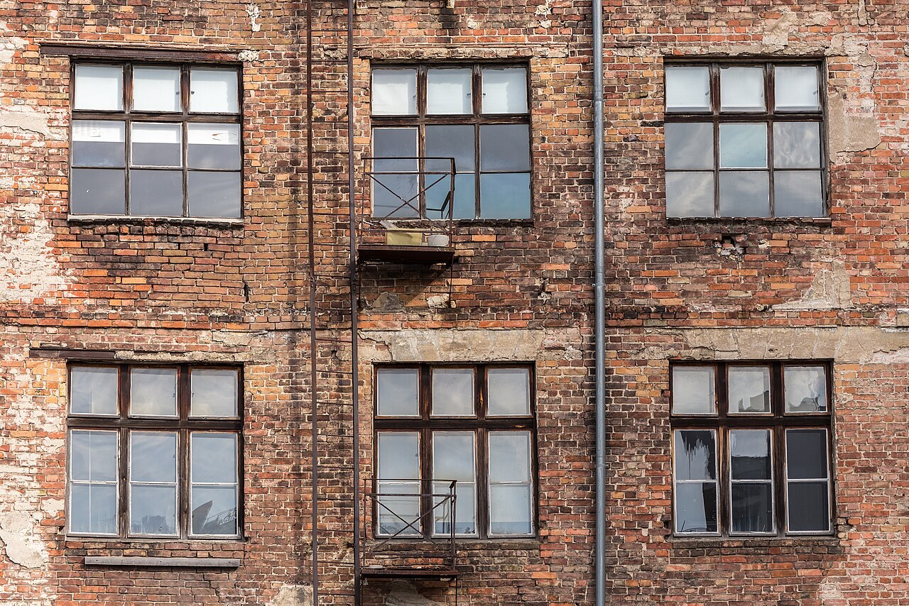 Backstein-Hoffassade eines Berliner Mietshauses mit Sprossenfenstern und kleinem Austritt, Kopenhagener Straße, Berlin-Prenzlauer Berg